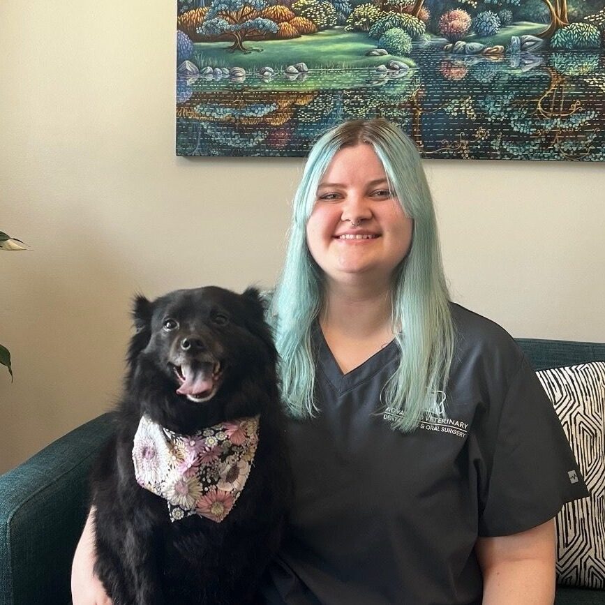 Riley smiling with a black dog